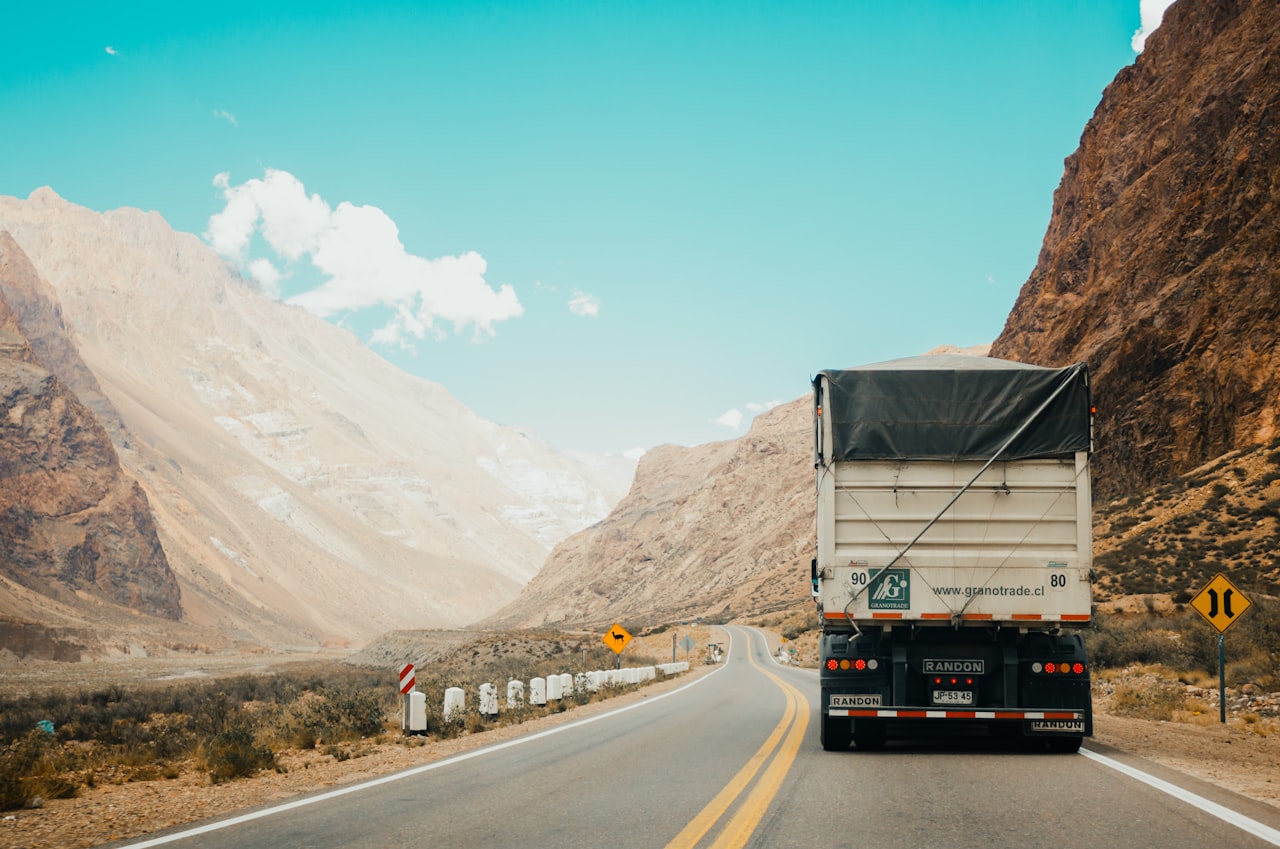 Transport truck driving along a highway through mountains